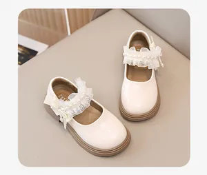 Dettaglio scarpe Mary Jane bianche da bambina con eleganti decori in pizzo e perle