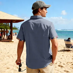 Back view of a men's grey beach shirt with colorful Bohemian patterned cuffs on sand