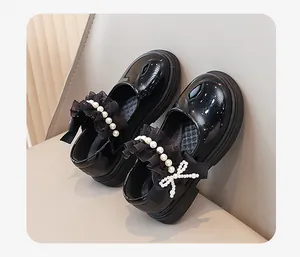 Primo piano di scarpe Mary Jane nere in vernice per bambina con dettagli in pizzo e perle