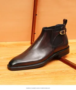 Bottine Chelsea pour homme en cuir marron foncé avec bout pointu et boucle décorative.