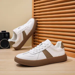 Detailopname van herenleren GAT-sneakers met wit bovenwerk en bruine rubberen zool