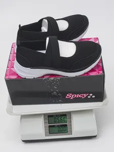 Gros plan sur baskets noires fly-knit pour femmes sur balance numérique pesant 0,560 kg