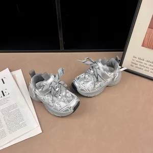 Vista detallada de zapatillas chunky plateadas para niñas con paneles de encaje y malla transpirable