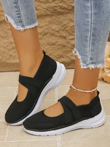 Vue latérale de baskets en maille noires pour femmes avec semelles blanches et sangles