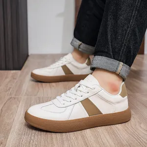 Detailed side view of men's white cowhide German trainers with khaki accents and gum soles