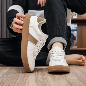 Close-up of white leather German Army Trainers with classic gum soles and lace-up design