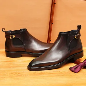 Bottines Chelsea en cuir marron pour hommes avec bout poli et boucle dorée élégante.