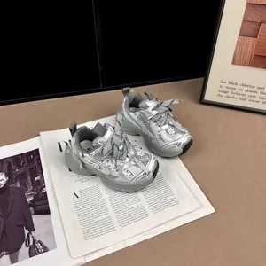 Detalle de zapatillas de malla plateada para niños con flores y cierre de velcro