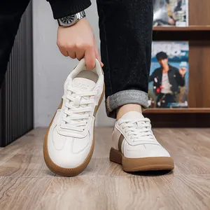 Close-up of white leather men's German Army trainers featuring a durable gum sole.