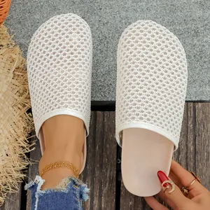 Detail shot of white woven mesh closed-toe mules showing textured upper and flat sole