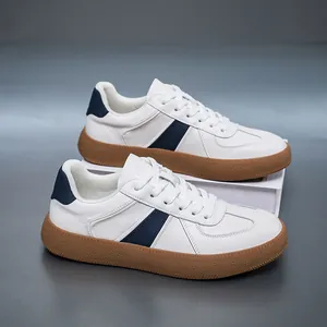 Detail view of white cowhide GAT sneakers with navy stripes and textured gum soles