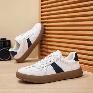 Detailed view of men's white leather GAT sneakers with a classic gum sole and blue stripe.