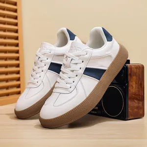 Premium white leather men's sneakers GAT style with navy stripes and textured gum sole.