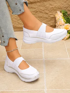 Gros plan de baskets blanches en mesh Mary Jane pour femmes portées par un mannequin