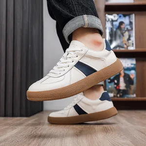 Detail view of men's white leather German trainer sneakers with classic gum sole
