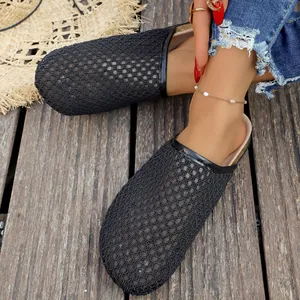 Close-up detail of women's retro black woven mesh closed-toe mules on a wooden deck