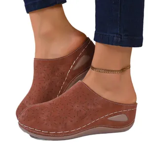 Women's stylish brown laser-cut suede closed-toe wedge mules featuring a round toe platform