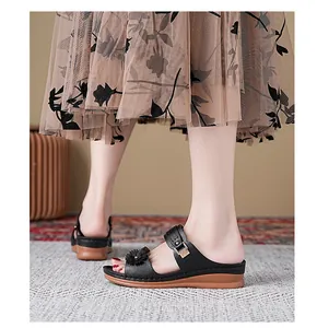 Close-up of black wedge sandals featuring a floral accent and comfortable thick sole