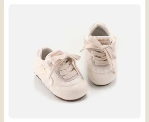 Nahaufnahme cremefarbener Kleinkind-Sneaker mit gestepptem Muster und Schleife