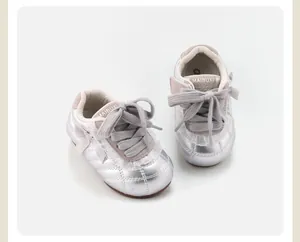 Detaillierte Draufsicht auf silberne Babyschuhe für Mädchen mit Schleifen und weichen Sohlen