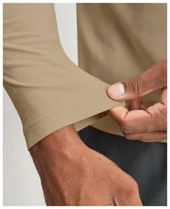 Close-up of quick-dry fabric and hem detail on khaki athletic long sleeve shirt.
