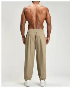 Rear view of khaki quick-dry athletic pants for men showing fit on a muscular model
