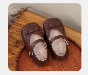 Top-down view of classic brown toddler girls' Mary Jane shoes featuring cute bow details.