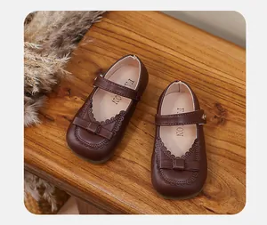 Top view of brown toddler girls' Mary Jane leather shoes with bow and lace detail