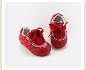 Detail von roten gesteppten Baby-Mädchenschuhen mit eleganter Spitze und Schleife