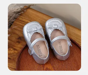 Detailed close-up of silver girls' Mary Jane princess shoes featuring a bow and white lace trim