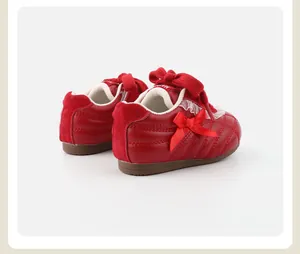 Detaillierte Rückansicht roter Mädchen-Sneaker mit niedlichen Schleifen- und Spitzenakzenten.