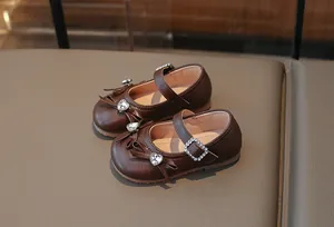 Detailansicht der braunen Mary Jane Schuhe für Mädchen mit Herz-Strass und Schleifenverzierung