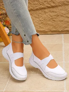 Vue latérale détaillée de baskets Mary Jane en maille blanche portées avec un jean décontracté.