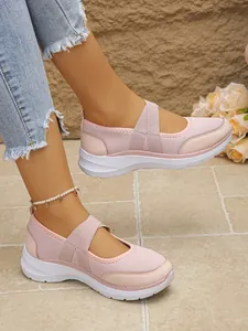 Détail rapproché des baskets en maille Mary Jane roses avec un short en jean effiloché
