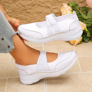 Gros plan de baskets Mary Jane blanches en mesh respirant avec brides croisées et décor argenté