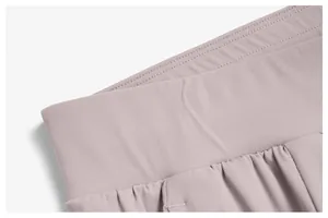 Detailed macro shot of the elastic waistband on lightweight mauve quick-dry sports pants