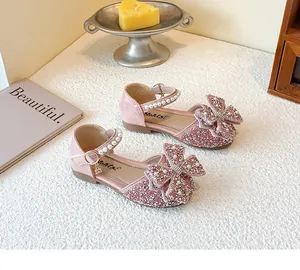 Detailed view of pink glittery girls' princess sandals with pearls and a large bow.