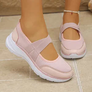 Gros plan des chaussures de sport roses en maille avec des brides élastiques croisées