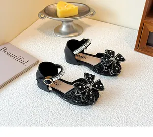 Elegant black girls' princess sandals featuring a large sparkling rhinestone bow detail.