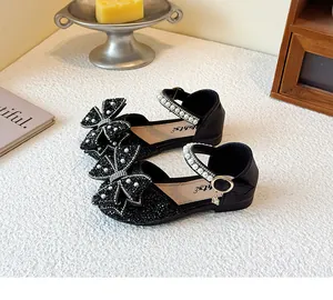 Detailed view of girls' black sequined princess sandals with ornate pearl bows