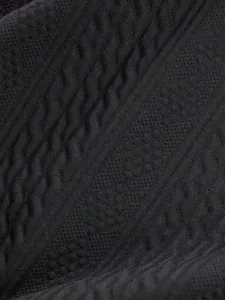 Detailed texture of black cable-knit jacquard fabric for men's autumn leisure top