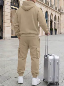 Back view of men's beige hooded tracksuit with cargo pants and stylish silver suitcase