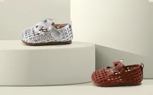 Detailweergave van het geweven holle ontwerp van zilveren en bruine prinsessenschoenen voor meisjes.