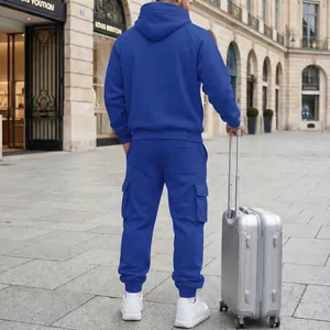 Back view of men's royal blue hooded tracksuit set with cargo joggers and suitcase.