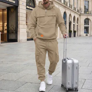 Fashionable man wearing a khaki hooded cargo tracksuit with suitcase on a city street