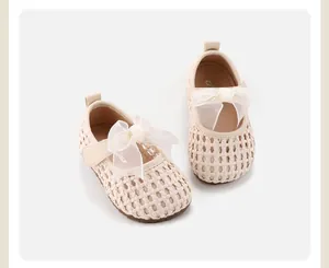 Beige woven baby girl shoes featuring a delicate white mesh bow and comfortable soft sole.