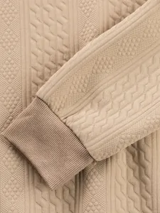 Detailed view of beige jacquard textured men's casual crew neck top with ribbed cuff.