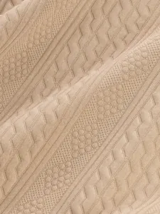 Close-up detail of textured beige jacquard knit fabric for men's autumn casual sweater.