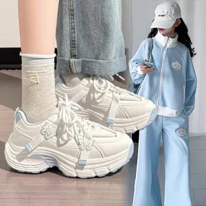 Side detail of chunky white sneakers with butterfly motifs and light blue accents