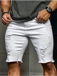 Détail d'un short en jean blanc pour homme avec déchirures prononcées et ourlet effiloché.